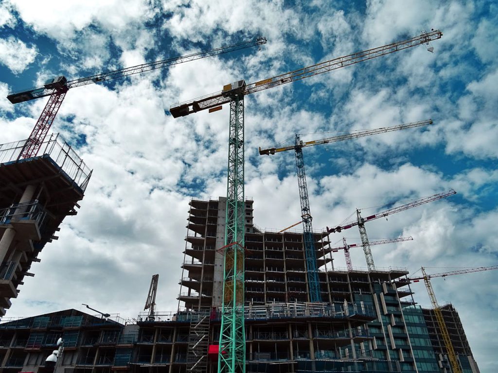 pexels-photo-439416 Urban construction site with numerous cranes framing rising skyscrapers against a blue sky.